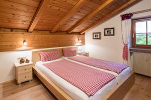 een slaapkamer met een groot bed met een houten plafond bij Ferienwohnung "Hüs 18" in Fischen
