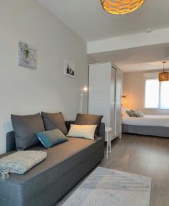 uma sala de estar com um sofá e uma cama em L'Ansolanette - Chambre d'hôtes em Fuveau