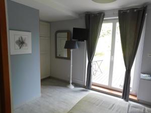 Cette chambre dispose d'une grande fenêtre avec des rideaux et une lampe. dans l'établissement L'AMANDAURE, à Saulcy-sur-Meurthe
