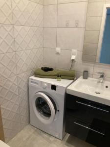 een badkamer met een wasmachine en een wastafel bij Apartament Fabryczna 35 in Białystok