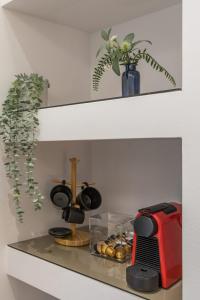 a shelf with pots and pans and a red toaster at Rooms - Unique staying in Paphos Centre in Paphos City