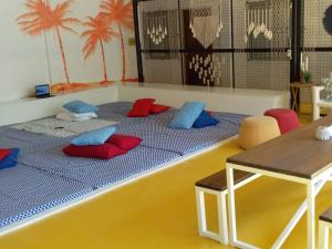 Elle comprend un grand lit avec des oreillers rouges et bleus. dans l'établissement MOHO, à Moalboal