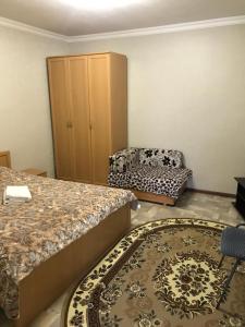 キスロヴォツクにあるApartment Lermontovaのベッドルーム1室(ベッド2台、椅子、ラグ付)