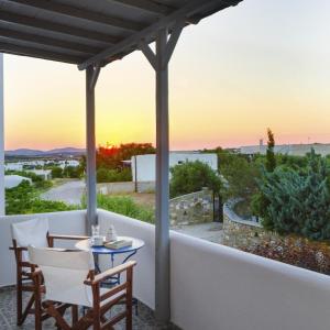 a patio with a table and chairs and the sunset at Anixis Studios Aliki Paros in Aliki