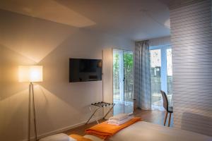 ein Schlafzimmer mit einem Bett und einem TV an der Wand in der Unterkunft H&H Apartment im Greifswald Eldena Nr19-Jonas mit Terrasse in Greifswald