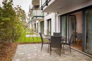 eine Terrasse mit einem Tisch und Stühlen auf dem Balkon in der Unterkunft H&H Apartment im Greifswald Eldena Nr19-Jonas mit Terrasse in Greifswald