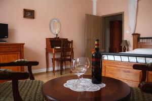 a bottle of wine and a wine glass on a table at Hotel Lony in Mochov