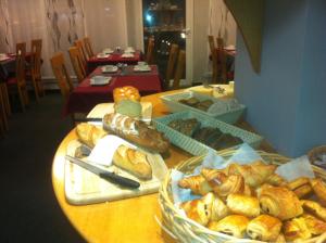 a table with a bunch of different types of bread at Amadeus Hotel in Sarreguemines