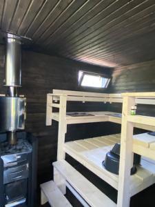 a small room with a bunk bed and a stove at Villa Falco in Espoo