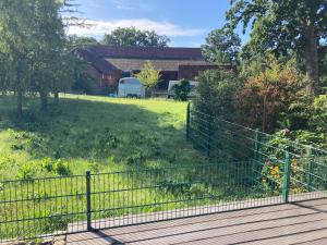 einen Zaun vor einem Hof mit einem Feld in der Unterkunft Ferienwohnung Bungenhof Alpacas in Celle
