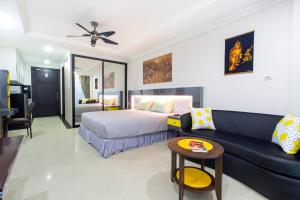 a hotel room with a bed and a couch at Beautiful Apartment A6 Central Pattaya in Pattaya +26 photos