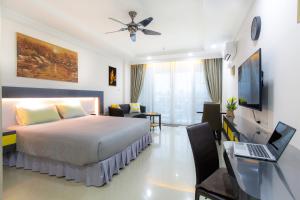 um quarto com uma cama e uma secretária com um computador portátil em Beautiful Apartment A6 Central Pattaya em Pattaya Central