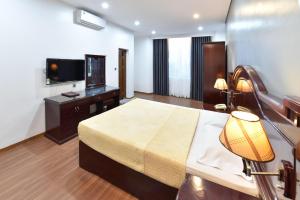 ein Hotelzimmer mit einem Bett und einem Flachbild-TV in der Unterkunft Gieng Ngoc Hotel in Cát Bà