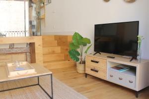 a living room with a flat screen tv on a cabinet at El Secreto de Portales in Logroño