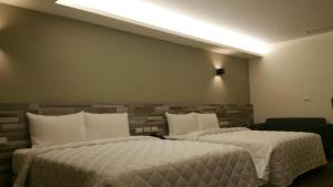 2 letti in una camera d'albergo con 2 letti sidx sidx di 萬酈精品旅館 a Kaohsiung