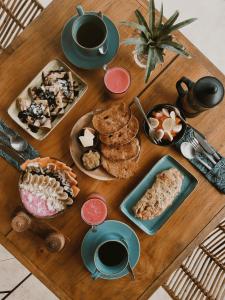a wooden table topped with plates of food and coffee at Autentik Penida "Glamping" - Adults only in Nusa Penida