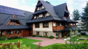 a large house with a roof with solar panels on it at Czarny Diament Domek in Biały Dunajec