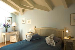 a bedroom with a blue bed with pillows on it at La Villetta in Raffa