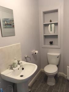 y baño con aseo blanco y lavamanos. en Causeway Street Holiday House Self Catering-Portrush, en Portrush