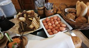 a table with eggs and bread and baskets of food at Apartmán 401 - Hotel s apartmánmi CROCUS . in Štrbské Pleso