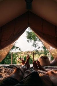 two people laying on a bed in a tent at Autentik Penida "Glamping" - Adults only in Nusa Penida