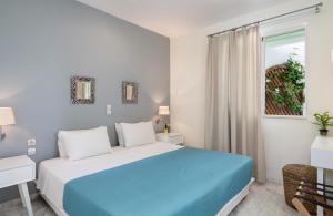 a bedroom with a blue and white bed and a window at Villa Life in Agia Marina Nea Kydonias +45 photos