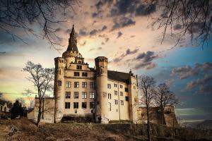 um velho castelo com uma torre numa colina em Schloss Arenfels em Bad Hönningen