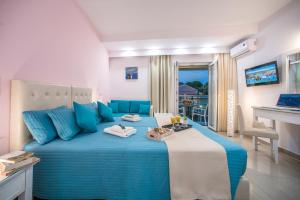 een slaapkamer met een blauw en wit bed met handdoeken erop bij Palotel Design Gouvia in Gouvia