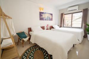 a hotel room with two beds and a window at Amor Fati home & Travel in Hanoi