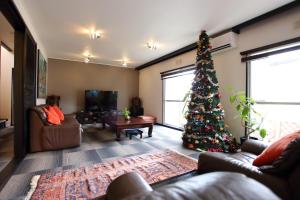 a living room with a christmas tree in it at Jonni`s Place in Sakamoto