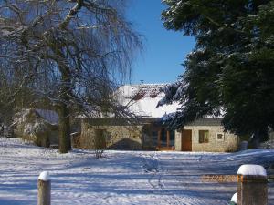 une maison avec de la neige au sol à côté d'un arbre dans l'établissement Che'Val d'Amour, à Écleux