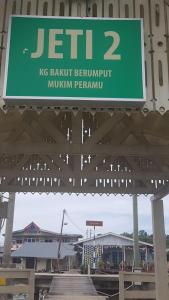 a green sign that reads ksync bartnut benututmillion penkunuri at Kunyit 7 Lodge in Bandar Seri Begawan