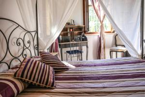 a bedroom with a bed with a canopy and pillows at La Puraza Comfort Rooms in Rimini