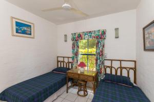 two beds in a room with a window at Santorini - Akrotiri 3 in Ballito
