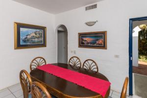 a dining room with a wooden table and chairs at Santorini - Akrotiri 3 in Ballito +6 photos