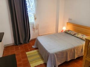 a small bedroom with a bed and a window at APPARTEMENT AGATHOIS-2 in Agde