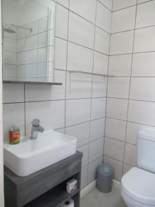 Baño blanco con lavabo y aseo en Royal@Sea2 en Muizenberg