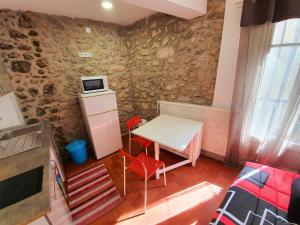 a small kitchen with a table and two red chairs at APPARTEMENT AGATHOIS-2 in Agde