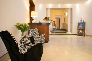 a lobby with two chairs and a table with flowers at Albergo Russo in Trapani