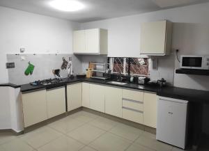 a kitchen with white cabinets and black counter tops at Guest House "Villa Klara Eilat" Heated pool and sauna all year round in Eilat