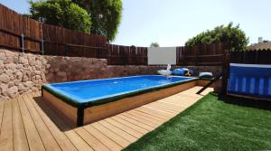 a swimming pool in a backyard with a wooden fence at Guest House "Villa Klara Eilat" Heated pool and sauna all year round in Eilat