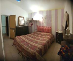 ein Schlafzimmer mit einem großen Bett und einem Spiegel in der Unterkunft La casa di Pasquino in Lama