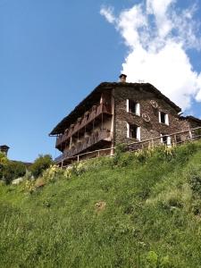 un vecchio edificio in cima a una collina erbosa di B & B La Guiette a Casteldelfino