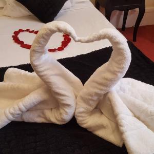 a pair of towels forming a heart on a bed at Hotel Raymond VII in Cordes-sur-Ciel