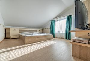 a bedroom with a bed and a flat screen tv at Pension Onix Vienna Airport in Maria Ellend