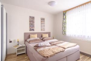 una camera da letto con un letto grande con una finestra di Ferienwohnung Agerblick 3 Zimmer mit Küche, 83m2 a Lenzing