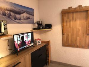 einen Flachbild-TV auf einer Kommode in der Unterkunft Studio 3 personnes idéalement situé, au pied des pistes et proche commerces in Vars
