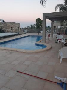 una piscina con una manguera roja en un patio en יחידת דיור עם בריכה פרטית מפנקת, en Rosh Pina