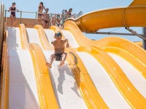 a young boy riding a water slide on a water park at Camping Les Palmiers in Hyères