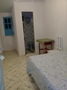 a bedroom with a bed and a table and a door at Suites para São João em Amargosa in Amargosa